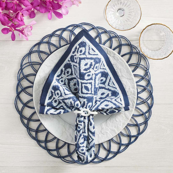 Blue faux rattan scalloped placemat by Kim Seybert on mediteranean tablescape.