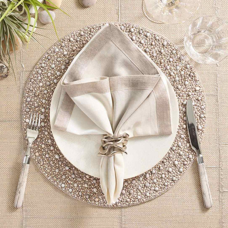 Gray and taupe Zen placemat with wood and glass bead detailing by Kim Seybert styled with silver accents.