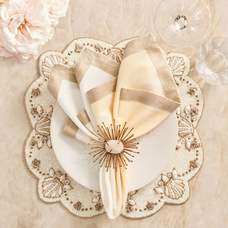 Beachcomber placemat with mother-of-pearl and gold shell with gold napkin ring.
