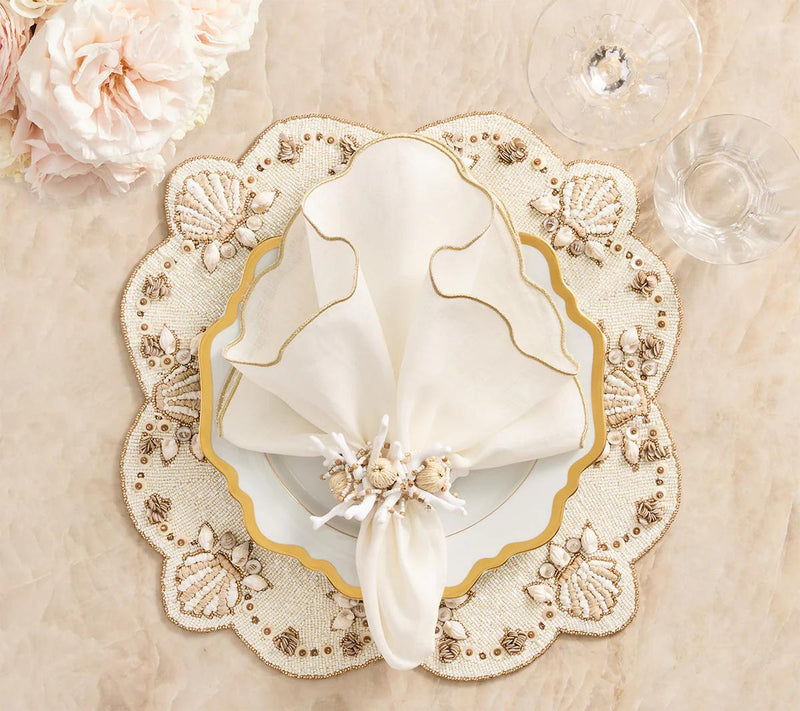 Beachcomber placemat with mother-of-pearl and gold shell accents styled with coral napkin ring.