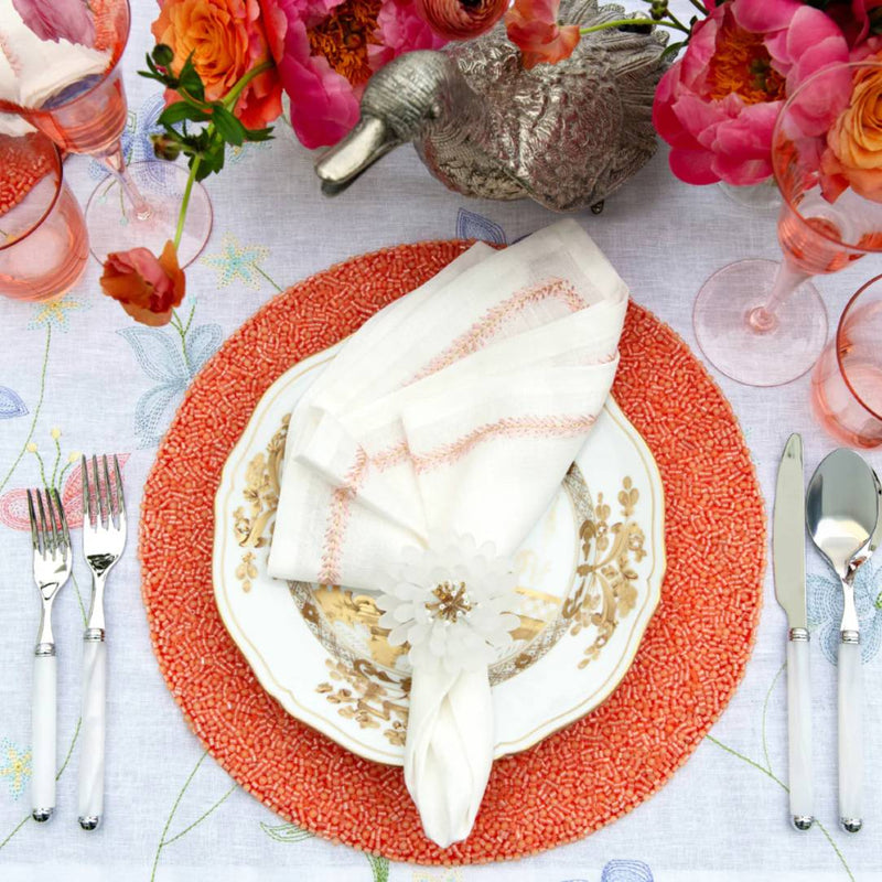 Coral Perennial placemat by Kim Seybertstyled with white napkin.