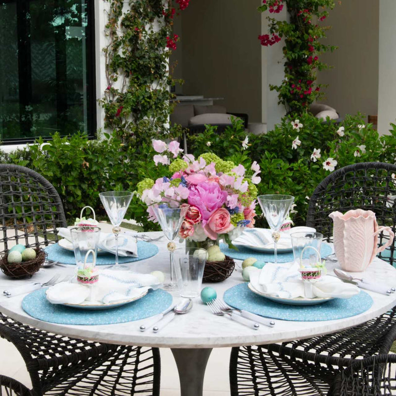 Periwinkle blue beaded placemat in vermicelli pattern on outdoor summer table.