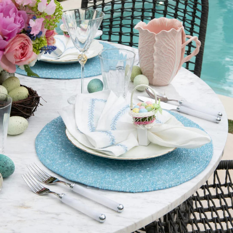 Periwinkle blue beaded placemat in vermicelli pattern on outdoor Easter tablescape.