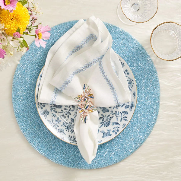 Periwinkle blue beaded placemat in vermicelli pattern with butterfly napkin ring.