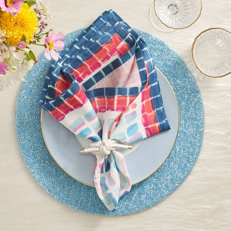 Periwinkle blue beaded placemat in vermicelli pattern with colorful napkin.