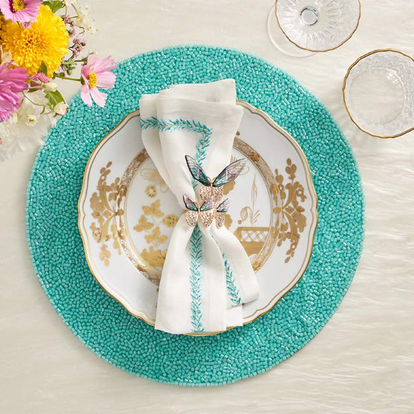 Turquoise placemat with translucent vermicelli beading styled with butterfly napkin ring.