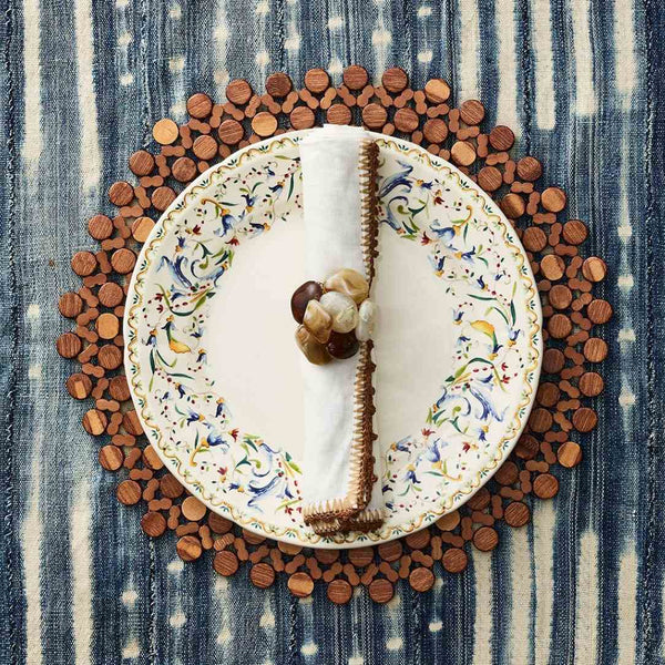 Brown bamboo round placemat by Kim Seybert styled with stone brown napkin ring. 