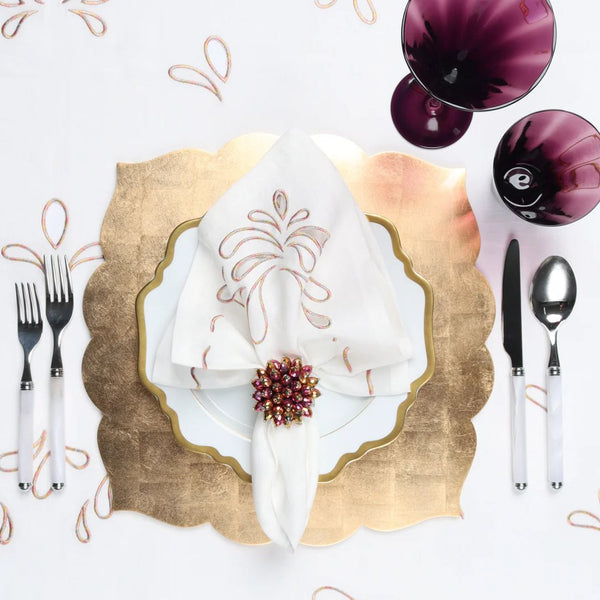 Champagne-gold Fez placemat with lacquer finish by Kim Seybert on festive tablescape.