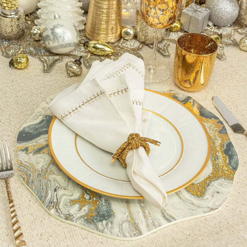 Kim Seybert Cosmos placemat with ivory, gold, and silver marbled design styled on festive gold tablescape.