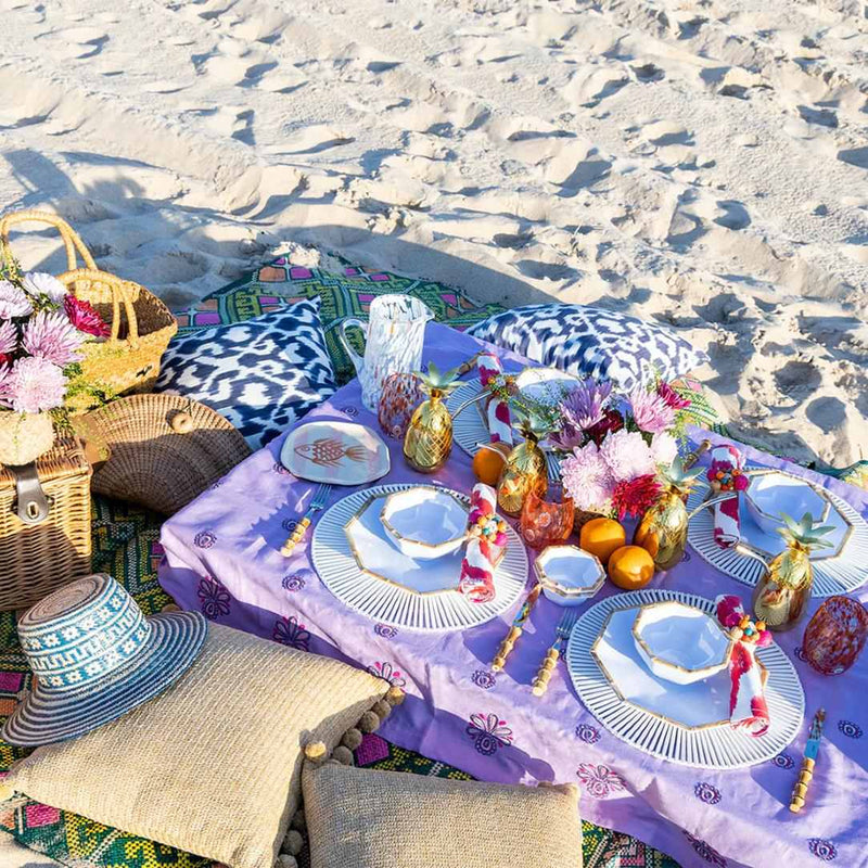 White spoke bamboo placemat by Kim Seybert styled on a coastal dining setup.