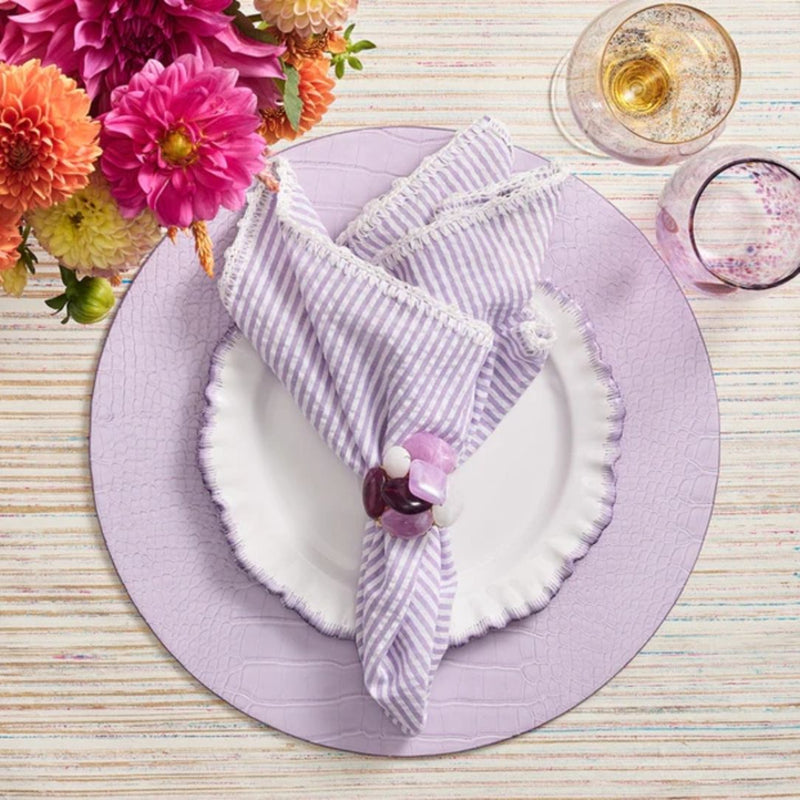Lilac faux croco round placemats by Kim Seybert, luxury tableware with purple napkin.