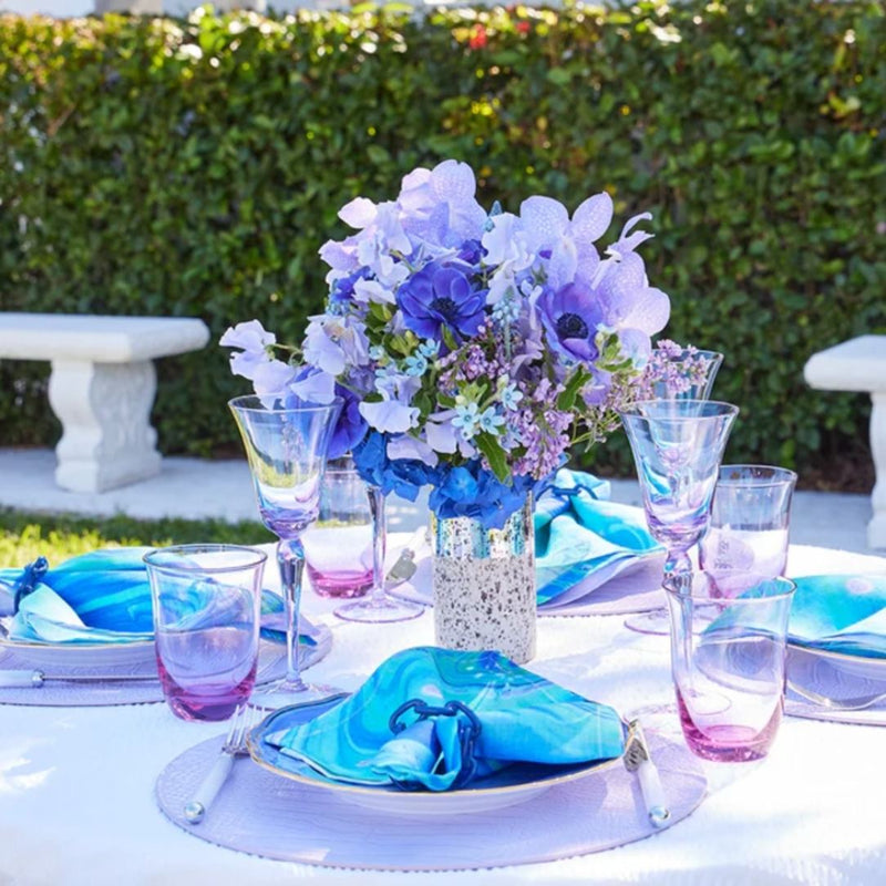 Lilac faux croco round placemats by Kim Seybert, luxury tableware on floral table setiing.