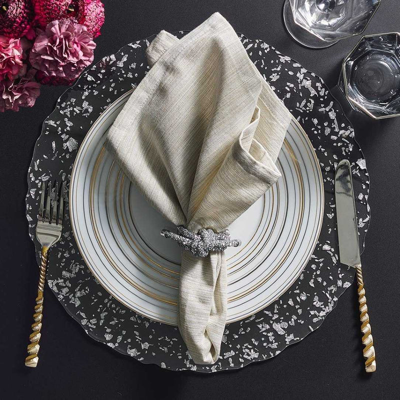 Clear acrylic placemat with silver flecks and wavy edge by Kim Seybert styled with siver accents.