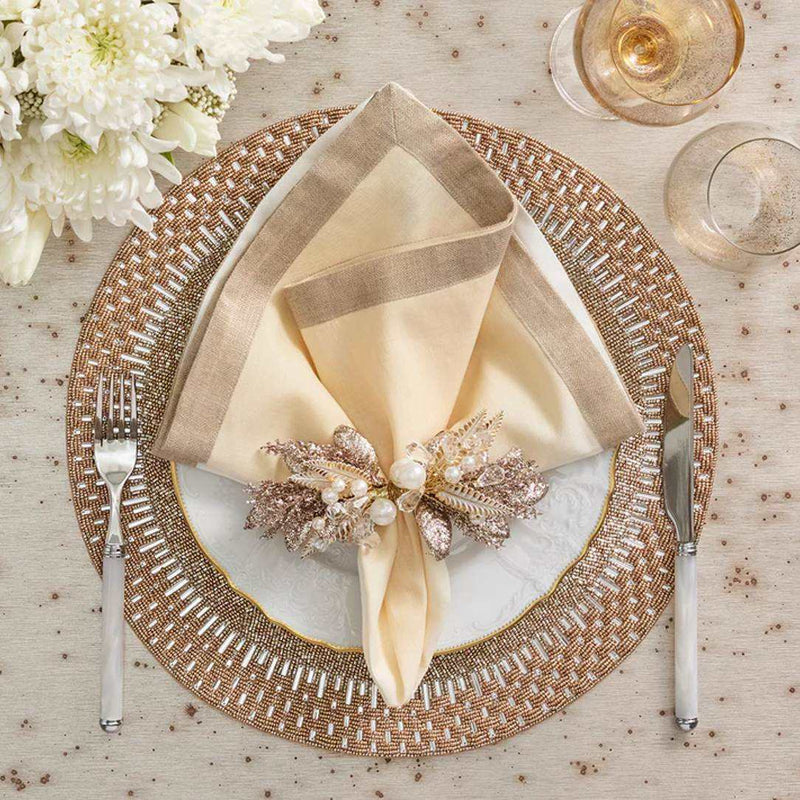 Luxury round placemat in gold and silver beadwork with beige napkin.