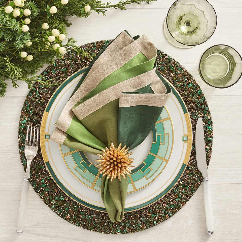 Green and gold beaded placemat with by Kim Seybert on festive tablescape.