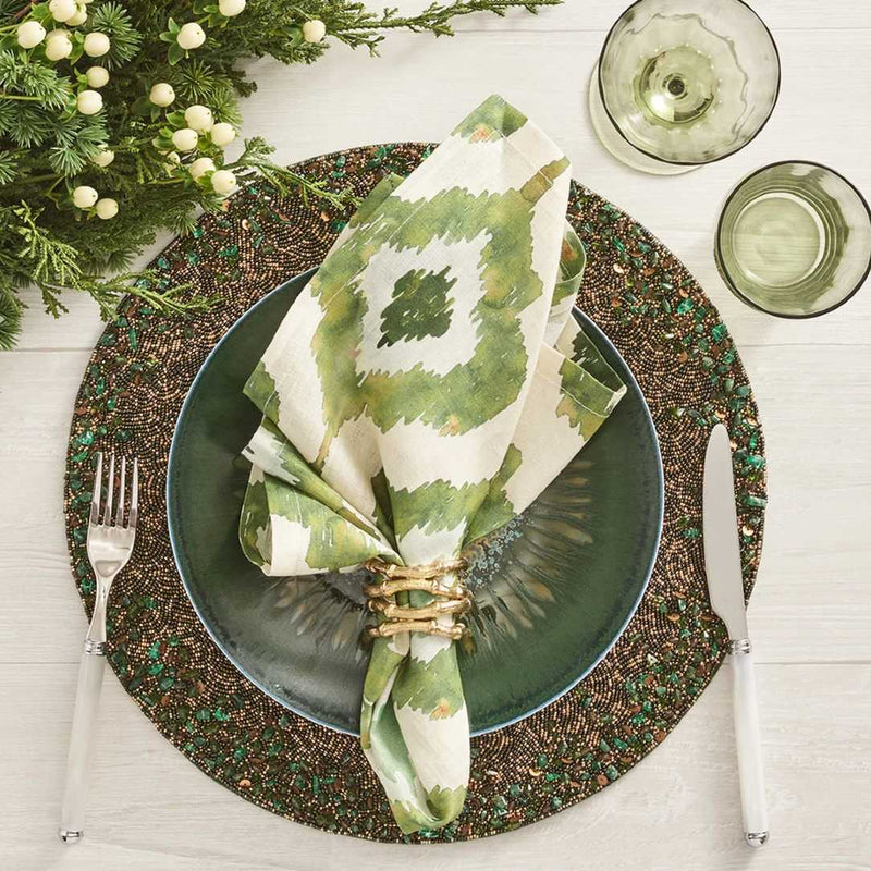 Green and gold beaded placemat with by Kim Seybert with green napkin.