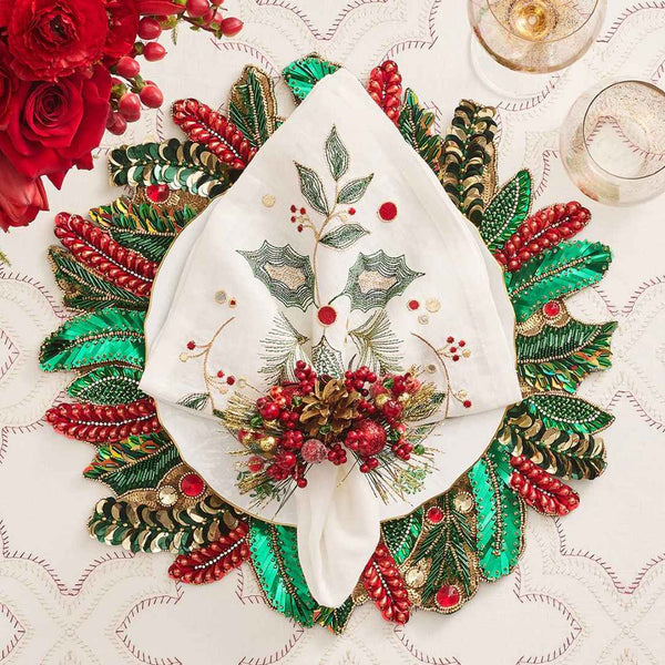 Beaded Christmas placemats with holly in green, red, and gold on luxury Christmas tablescape.