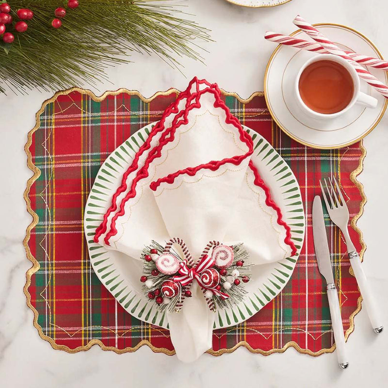 Red tartan placemat with gold embroidered scalloped edge with candy cane napkin ring.