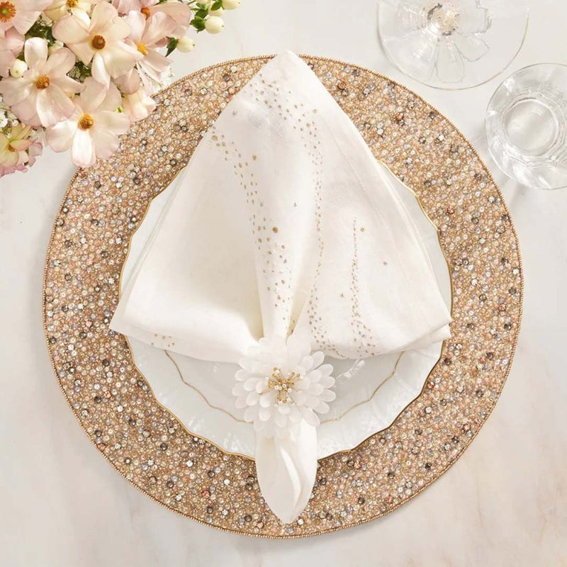 Hand-beaded champagne and crystal round placemat by Kim Seybert on elegant table setting.