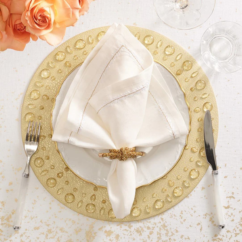 Gold Dew Drops placemat with resin gemstone border by Kim Seybert styled with gold napkin ring.