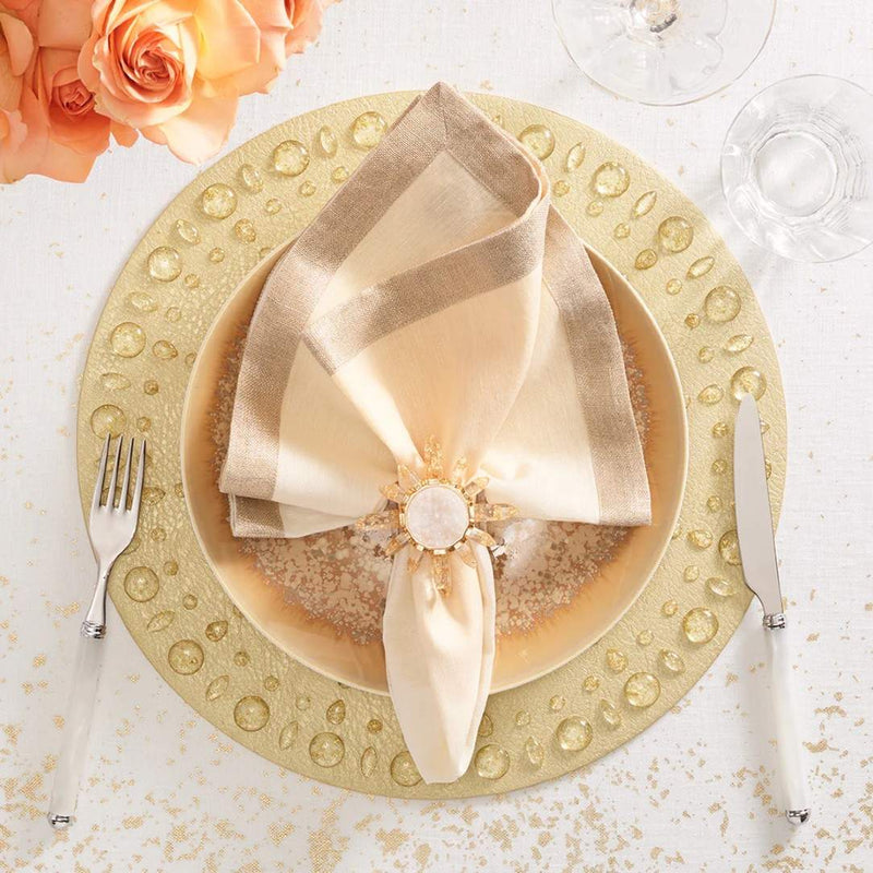 Gold Dew Drops placemat with resin gemstone border by Kim Seybert with cream napkin.