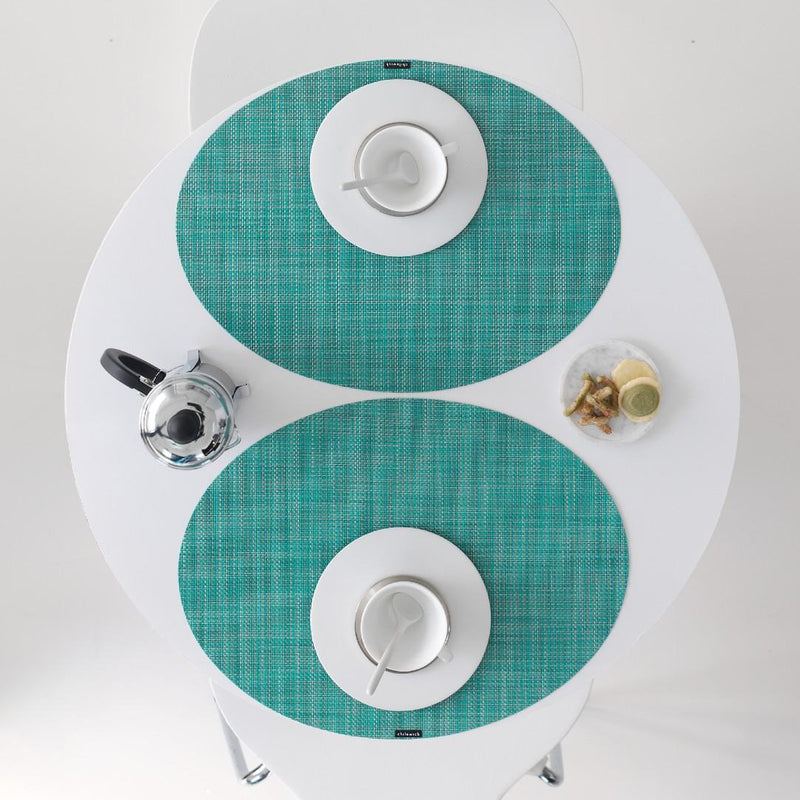 Oval turquoise Mini Basketweave placemat by Chilewich on luxury breakfast table setting.