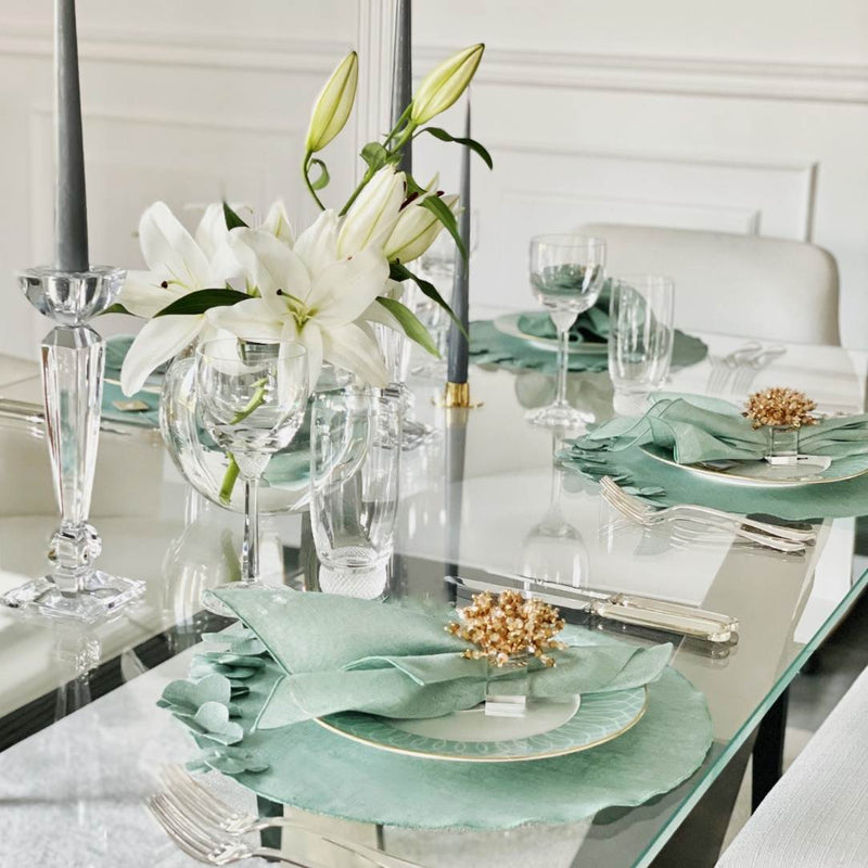 Sage green round linen placemat with 3D applied flowers on luxury tablescape.