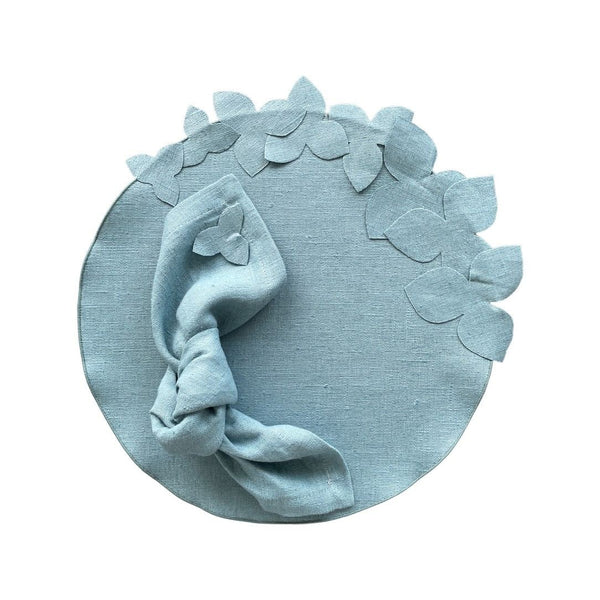 Sky blue round linen placemat with 3D hydrangea flowers with napkin from same collection.