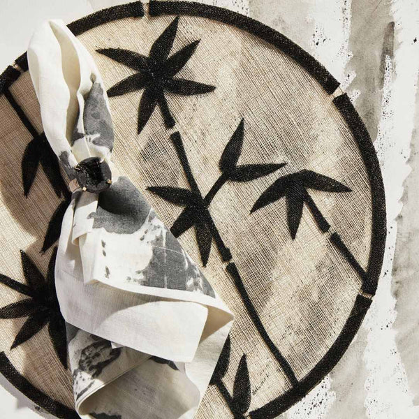 Black straw placemat with bamboo motif by Joanna Buchanan on boho chic table decor.