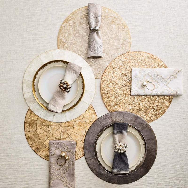 Natural Capiz shell round placemat with pearlescent finish by Kim Seybert in different colour options.