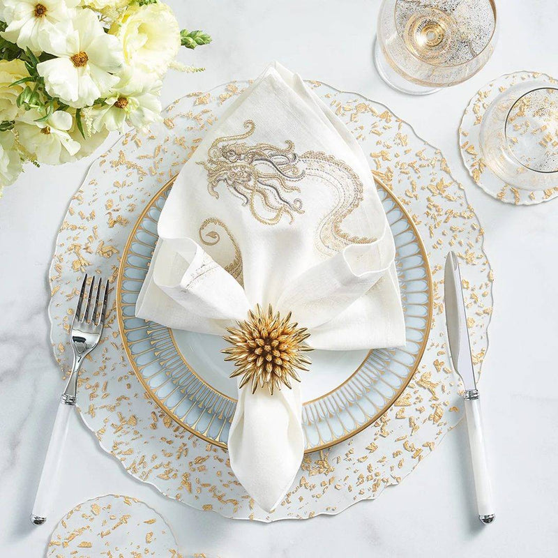 Clear acrylic placemat with gold flecks and wavy edge by Kim Seybert with gold napkin ring.