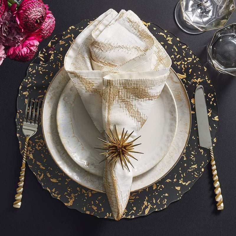 Clear acrylic placemat with gold flecks and wavy edge by Kim Seybert with gold napkin.
