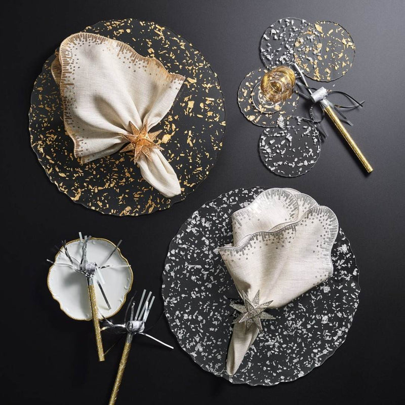 Clear acrylic placemat with gold flecks and wavy edge by Kim Seybert next to silver version.