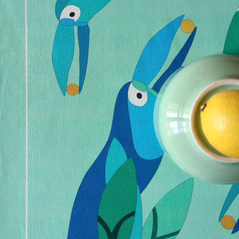 Reversible placemat with foliage motif and toucan design toucan motif close-up.