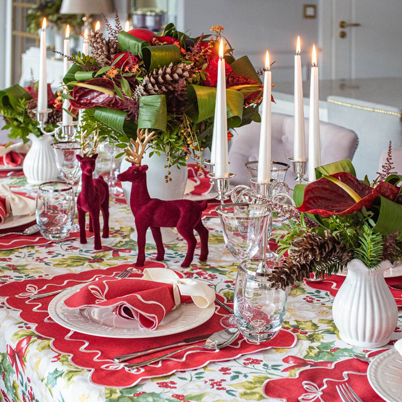 Red cotton placemat embroidered with white Christmas bows on luxury Christmas tablescape.