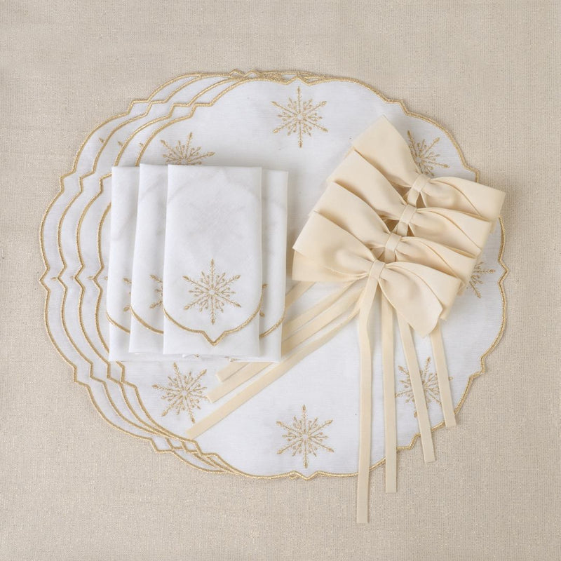 White cotton placemat with gold star embroidery by Roseberry Home with matching napkins and bows.