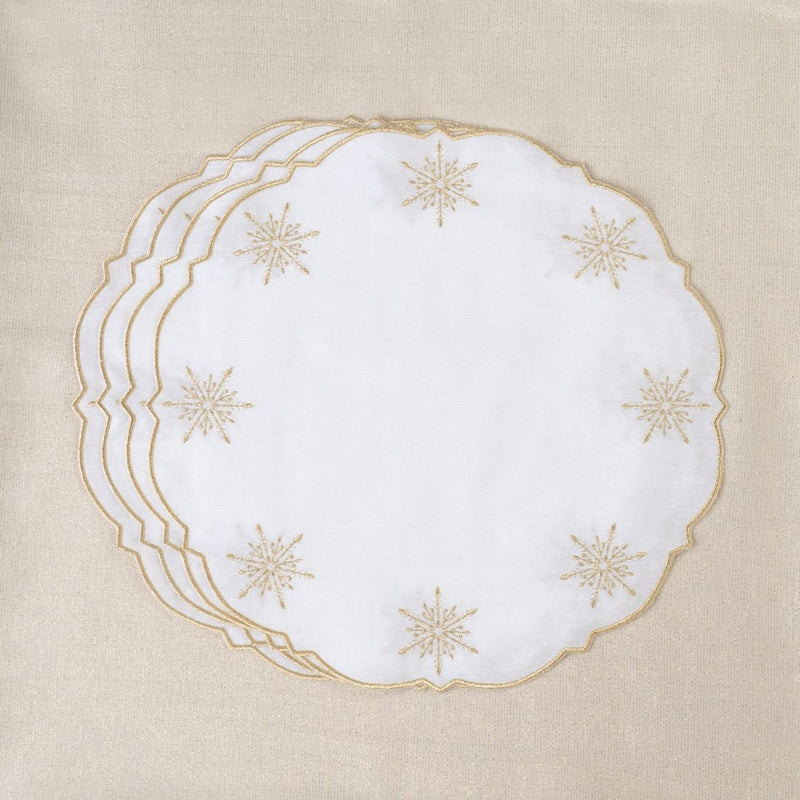 White cotton placemat with gold star embroidery by Roseberry Home stacked on gold tablecloth.