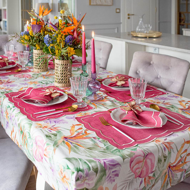Pink placemat with ecru embroidery and irregular wave border on luxury summer colourful tablescape.