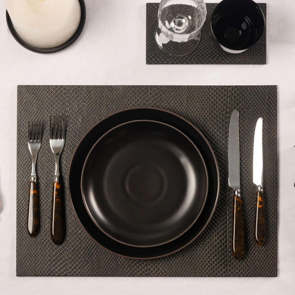 Charcoal faux boa placemat with textured finish in dark brown and grey styled with luxury table accessories.