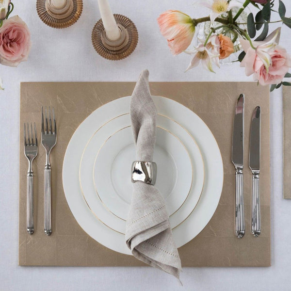 Champagne silver leaf placemat with matte lacquered finish styled on luxury tablescape.