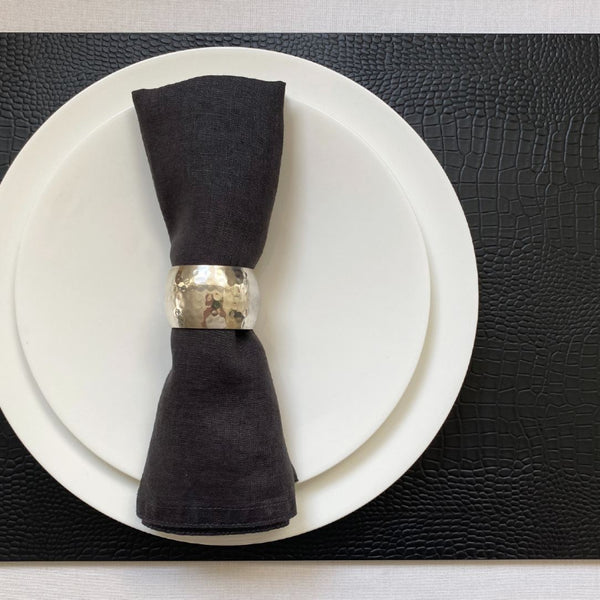 Black faux python placemat with detailed reptile scale pattern with black napkin.