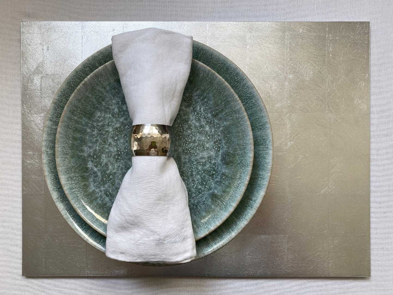 Handcrafted placemat made from genuine silver leaf with lacquer finish styled with beige napkin.