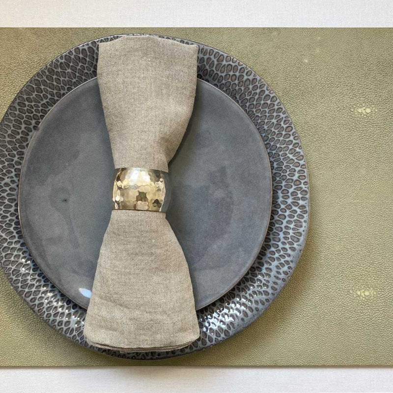 Natural faux shagreen placemat with hand-polished finish with beige napkin.