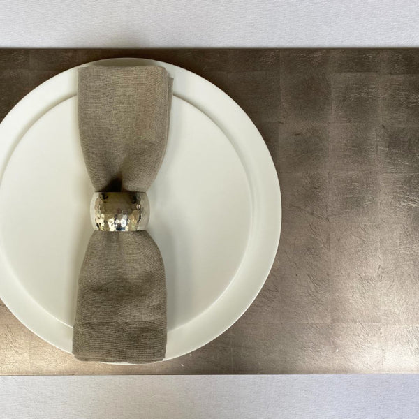 Taupe silver leaf placemat with polished lacquered finish with luxe taupe napkin. 