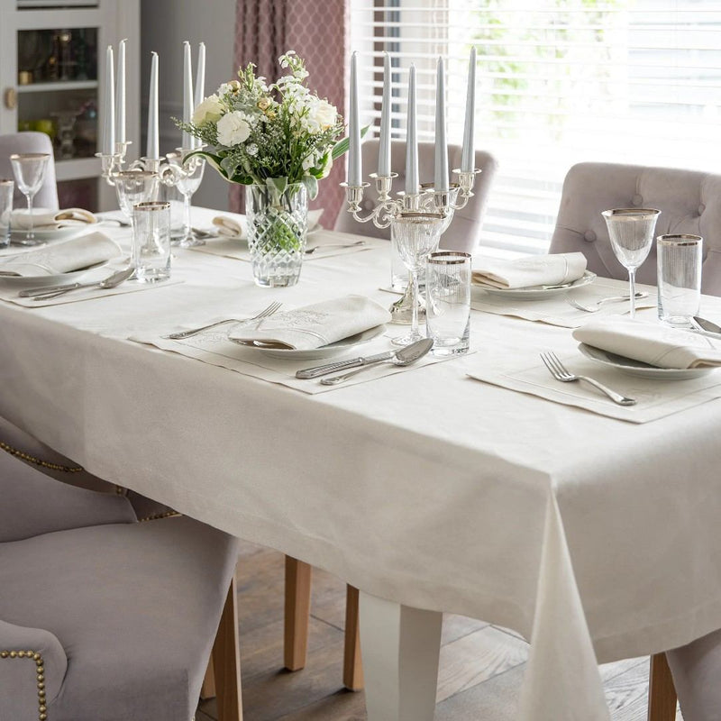Silver placemat set with embroidered Christmas bells and border styled on Christmas tablescape.