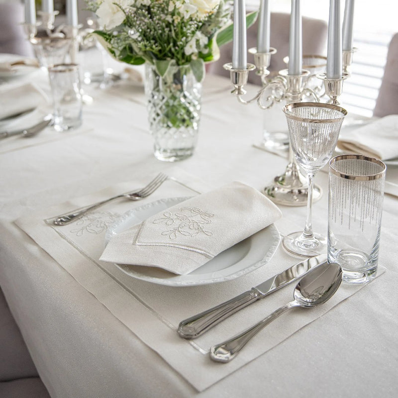 Silverline placemat with stitched border and mistletoe design on Christmas tablescape.