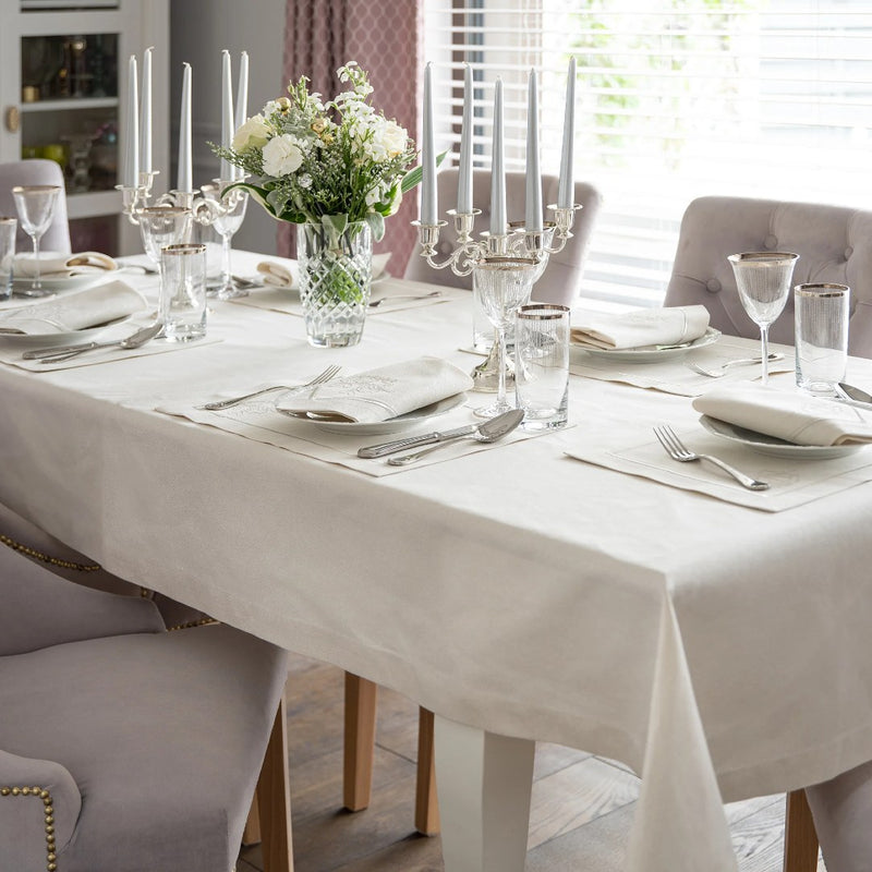 Silverline placemat with stitched border and mistletoe design styled on luxury festive tablescape.