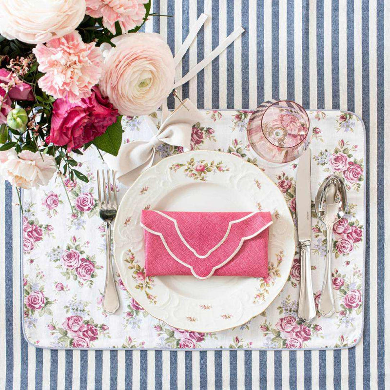 Double-sided cotton placemat rose motif side styled on chic striped tablescape.