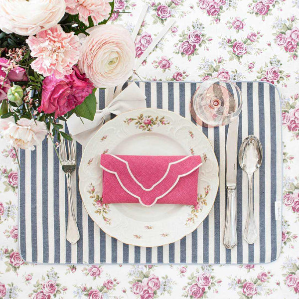 Double-sided cotton placemat blue-beige stripes side styled on floral tablescape.
