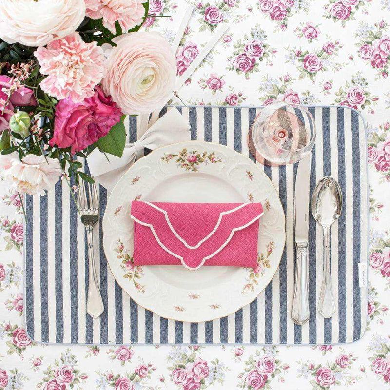 Double-sided cotton placemat blue-beige stripes side styled on floral tablescape.